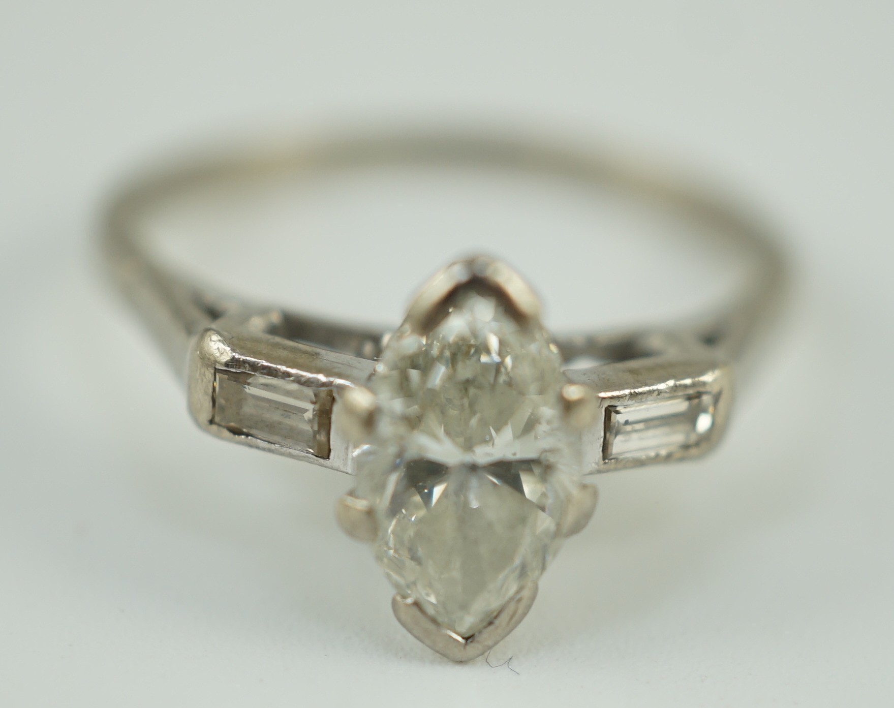 An 18ct white gold and single stone marquise cut diamond set ring, with baguette cut diamond set shoulders